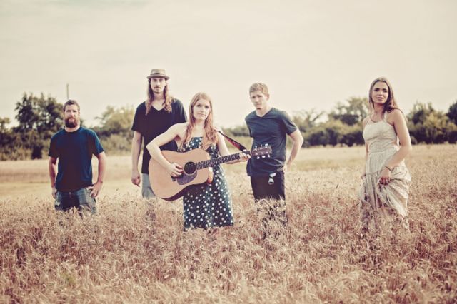 The musicians Erika Hughes and the Well Mannered standing in a field